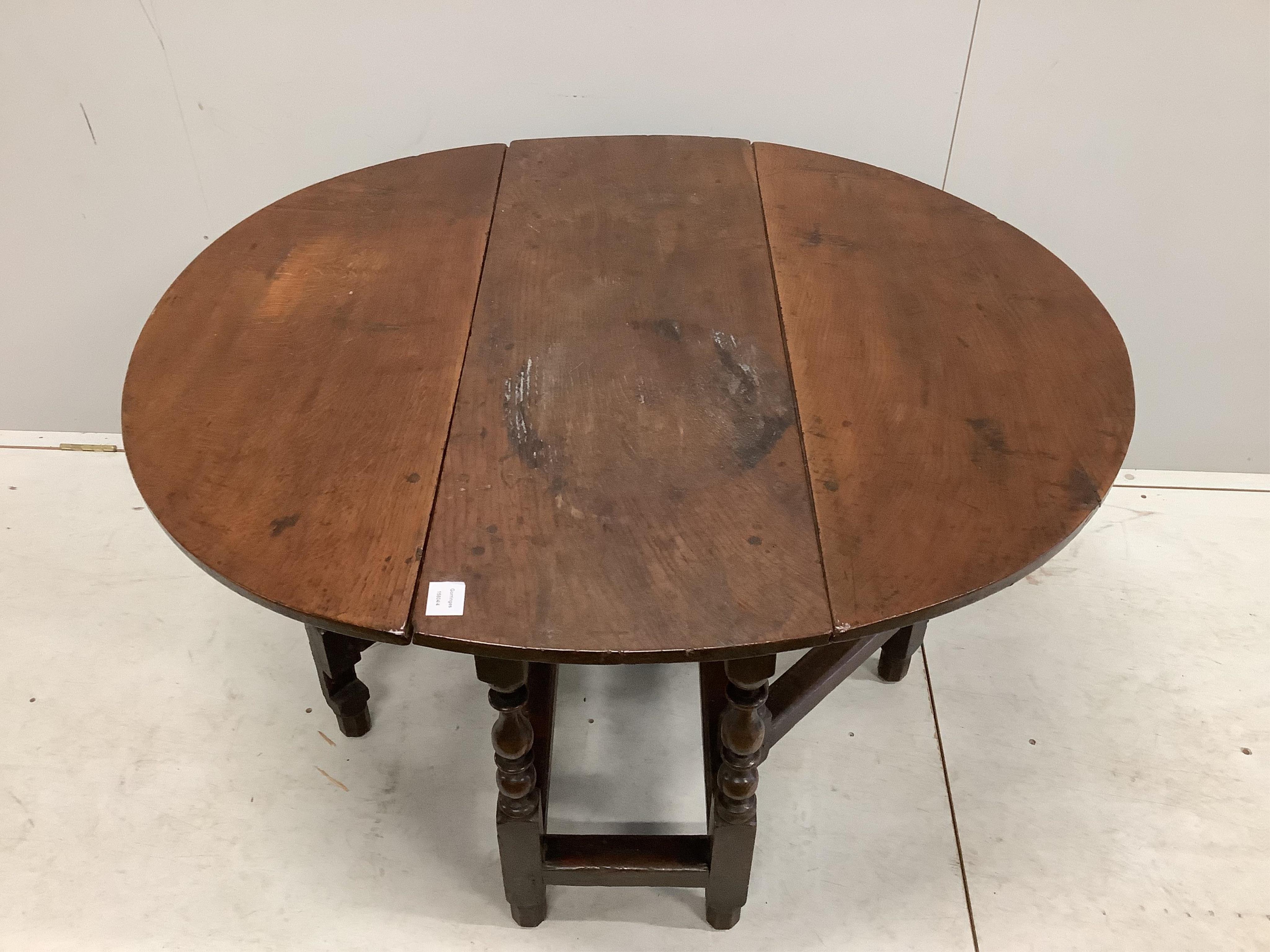 An 18th century oak gateleg table with an oval top on baluster turned under frame, 112cm extended, depth 100cm, height 68cm. Condition - fair